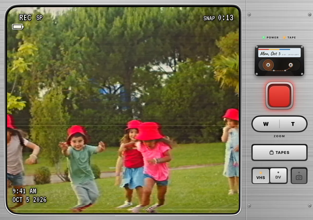 Flipcorder on the inside screen of iPhone Duo, in the simulator: a wide viewfinder reading REC SP and SNAP 0:13 over children in red hats running across a lawn, with the deck down the right-hand side, the cassette, the big red key, the zoom rocker, TAPES and the VHS and DV keys.
