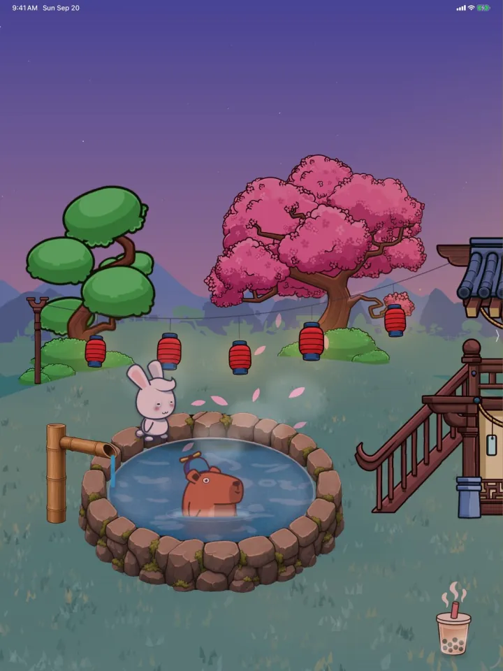 Bobara on iPad at dusk: Momo the capybara soaks in a round stone hot spring under a pink cherry tree and red paper lanterns, with a white rabbit on the rim.