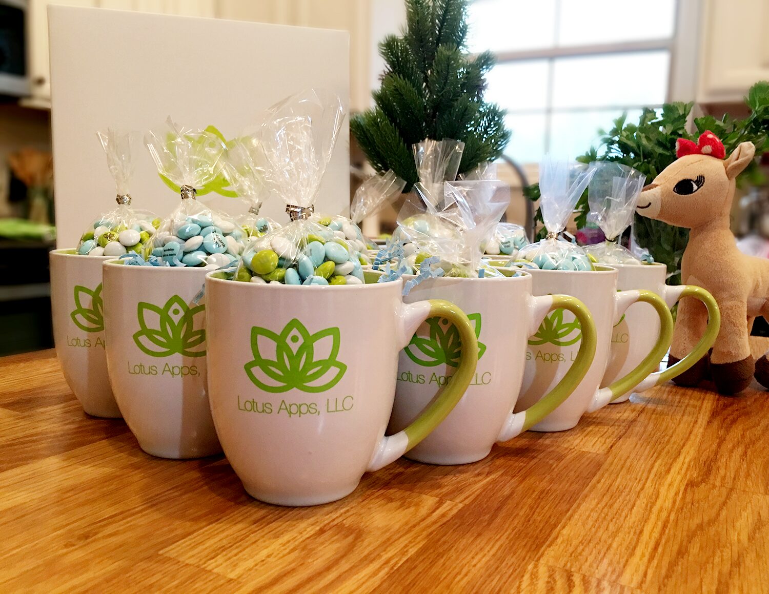 Lotus Apps mugs filled with bags of custom candy, lined up on a table