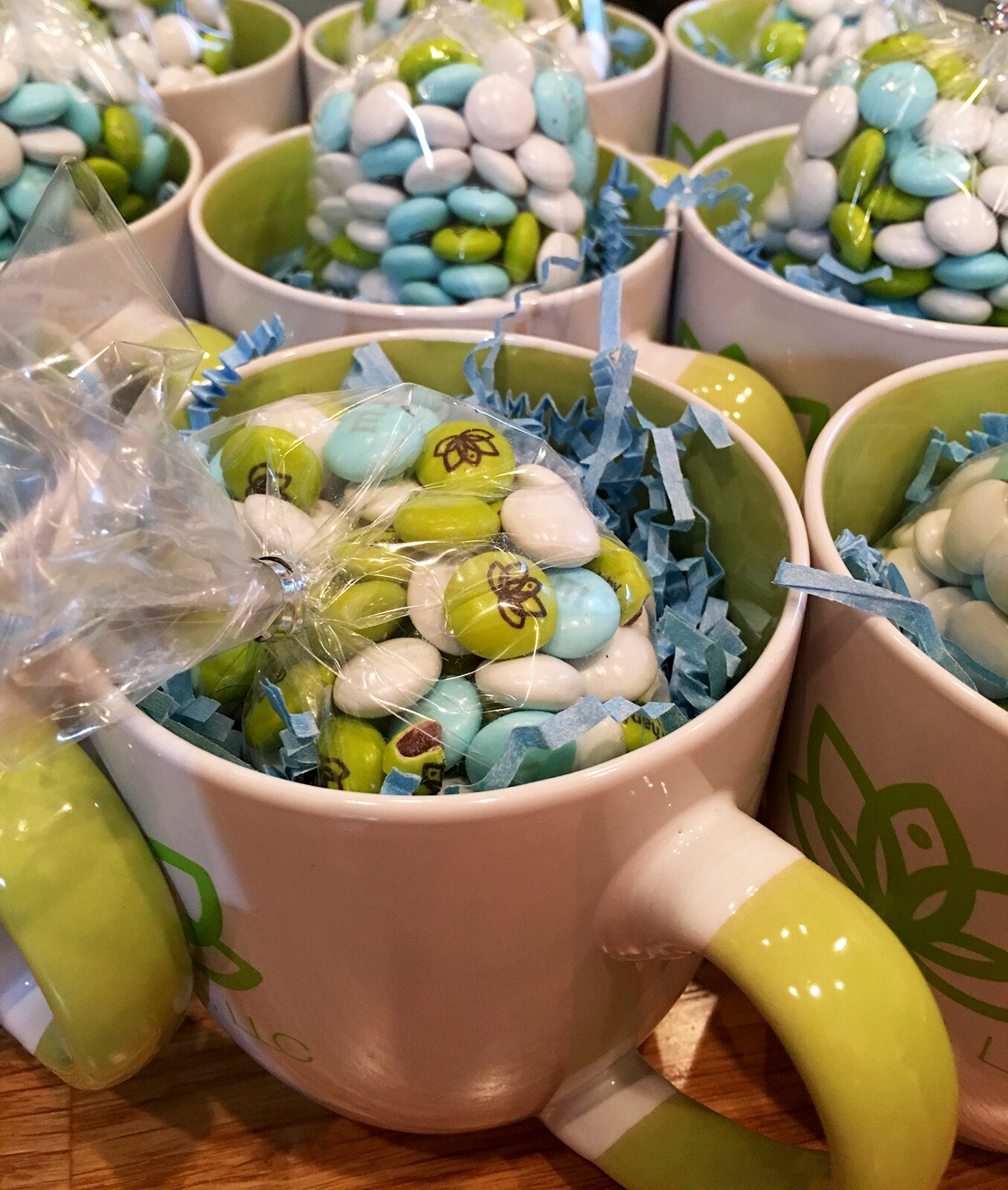 Close-up of Lotus Apps mugs filled with blue, green and white custom M&Ms