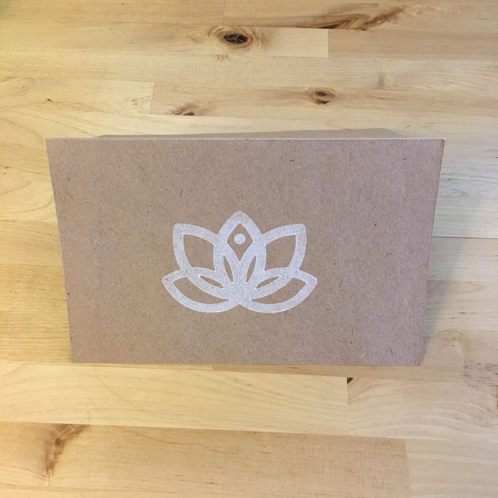 A kraft paper card stamped with the Lotus flower in white