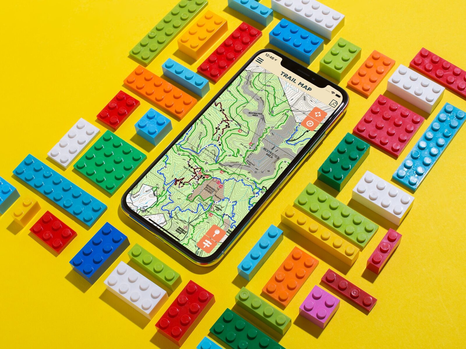 The Windrock Park trail map app on an iPhone, surrounded by Lego bricks